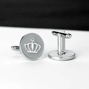 Detailed close-up of round silver cufflinks with 3D crown emblem and swivel toggle closure