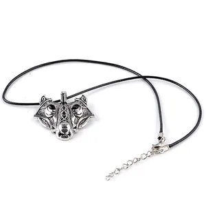 Detail of vintage silver wolf head pendant with Nordic carvings and black cord