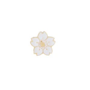 Détail de la broche fleur de cerisier blanche avec bordures dorées et étamines