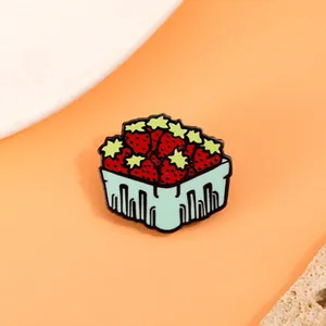 Detailed view of a cute cartoon strawberry basket brooch with colorful enamel finish