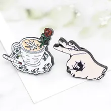 Macro detail of enamel pins featuring a coffee cup with rose art and elegant hand gesture