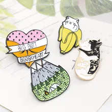 Detail of four creative enamel pins set featuring cat, heart and camping scene motifs