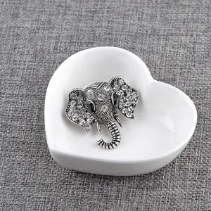 Detailed close-up of elephant brooch with sparkling rhinestones in a ceramic tray