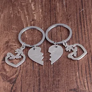 Llaveros de pareja en plata con colgantes de corazón y caligrafía árabe sobre madera oscura
