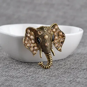 Detailed close-up of retro elephant head brooch with amber rhinestones on gold metal