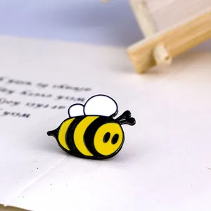 Macro detail of a cute cartoon bee enamel brooch with yellow and black stripes