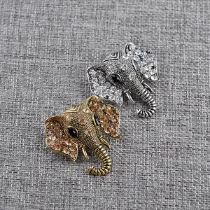 Detailed macro view of gold and silver elephant brooches with rhinestone accents