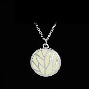 Macro shot of silver hollow Tree of Life pendant necklace with luminous light yellow inlay