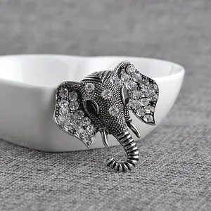 Vintage elephant brooch in silver alloy with sparkling rhinestones and black gem eyes