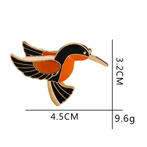 Spilla a forma di colibrì smaltato in metallo dorato con misure di 3,2 cm x 4,5 cm