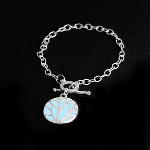 Detail of silver tree of life pendant with light blue enamel and toggle clasp chain