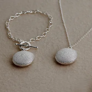 Detail of silver tree of life jewelry set with textured finish and toggle clasp chain