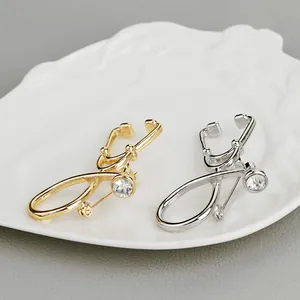 Stethoscope brooch set in gold and silver finish with sparkling rhinestone accents