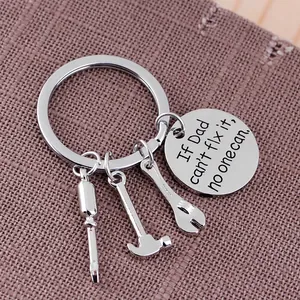 Macro detail of Dad Can't Fix It keychain with mini hammer, wrench, and screwdriver tools