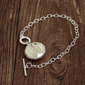 Detailed shot of Tree of Life pendant with toggle clasp on a dark wood background