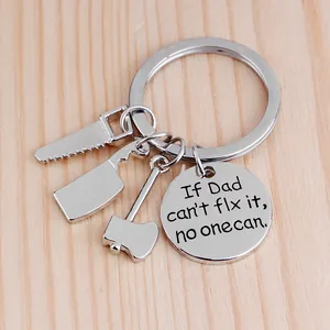Close-up of mini tool charms and engraved Dad quote plaque on a metal keychain