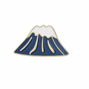 Détail du pin's émaillé Mont Fuji avec montagne bleue, sommet blanc et bords dorés