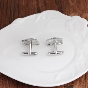 Close-up of silver-tone triangle cufflinks with textured finish and T-bar fastening