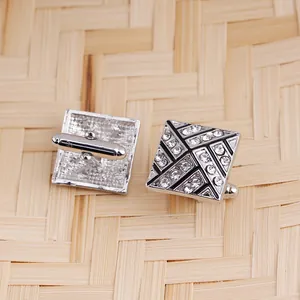 Detailed view of silver square cufflinks with black enamel inlay and sparkling crystals