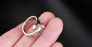 Detail of silver ring with engraved love you forever text and cutout heart paw prints