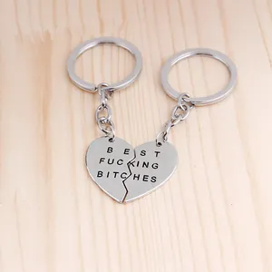 Detail van gedeelde BFF-sleutelhangers met Best Fucking Bitches gravure op houtoppervlak