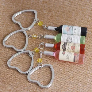 Detail of four miniature resin wine bottle keychains with heart-shaped metal rings
