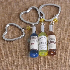 Close-up of resin miniature wine bottle keychains in blue, yellow and red colors