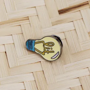 Schattige emaille broche in de vorm van een lamp met lit tekst op bamboe achtergrond