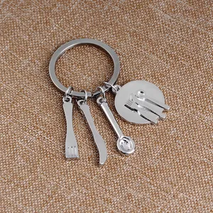 Detail of silver kitchen utensil charms on a stainless steel keychain gift
