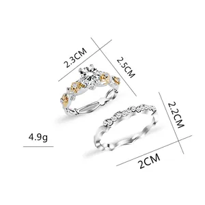 Conjunto de dos anillos en plata y oro con piedra central redonda y banda de diamantes