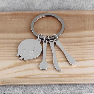 Creative kitchen tool keychain with spoon and knife charms on a rustic wood background