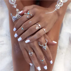 Bohemian silver ring set featuring heart arrow and reindeer designs on a beach setting