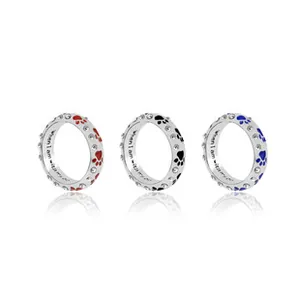 Detailed view of paw print rings in red, black, and blue with custom engraved text