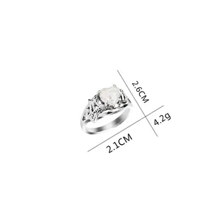 Silver ring with heart-shaped white opal stone featuring artistic openwork text design