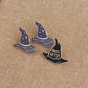 Macro view of wizard hat enamel pins with Wizard in Training and Basic Witch text