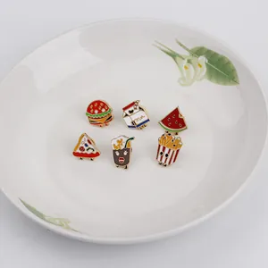 Cartoon food enamel pin set featuring burger and pizza designs in a decorative ceramic plate