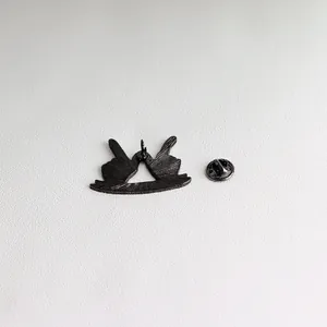 Detail view of the black enamel brooch back with brushed metal texture and butterfly clasp