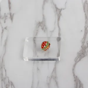 Close-up of a mini burger enamel pin showing colorful layered details on acrylic stand