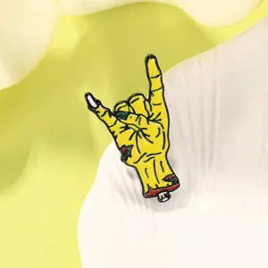 Close-up of a rock-on zombie hand enamel pin on a clean minimalist background