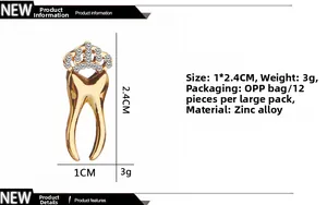 Detail of gold tooth brooch with crown and white rhinestones, size 1x2.4cm on white base