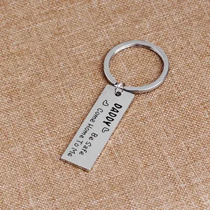 Close-up of engraved silver keychain with Daddy Be Safe message on textured background