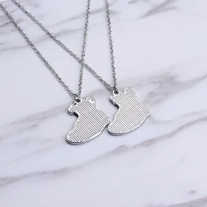 Detailed macro view of silver sneaker-shaped pendants with textured finish on marble