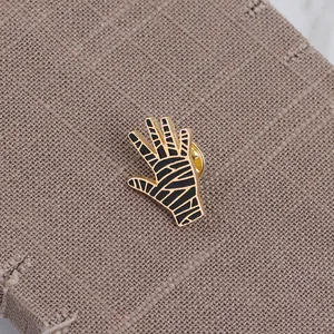 Close-up of Halloween mummy palm enamel pin with gold plating and butterfly clutch