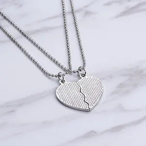 Silver best friends interlocking heart pendant necklaces on marble background
