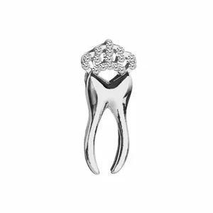 Detailed view of silver tooth charm with sparkling zircon crown on white background