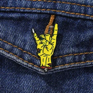Zombie hand rock gesture enamel pin badge on dark blue denim jacket pocket accessory