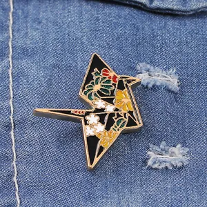 Detail of lightning enamel pin with floral patterns on blue denim jacket fabric