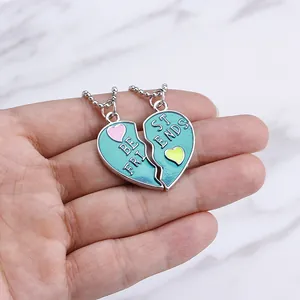 Blue enamel heart Best Friends necklaces with silver bead chain shown against marble