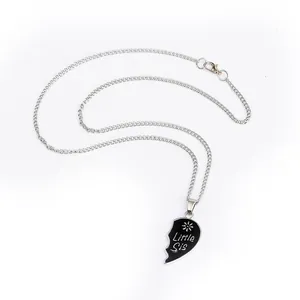 Detailed macro view of Little Sis silver necklace with black heart and floral patterns
