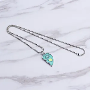 Detail of teal enamel half-heart pendant with 'ST ENDS' text on silver bead chain